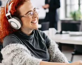 woman sat at desk with headphones