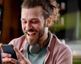 Man on phone at desk looking happy